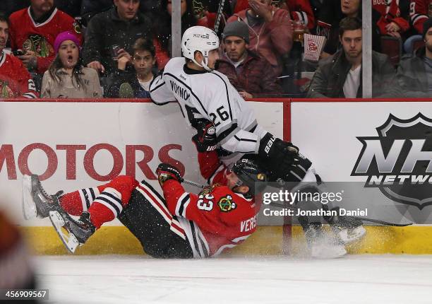 Slava Voynov of the Los Angeles Kings falls on top of Kris Versteeg of the Chicago Blackhawks at the United Center on December 15, 2013 in Chicago,...