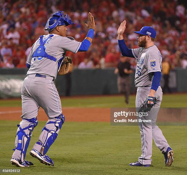 Salvador Perez and Greg Holland of the Kansas City Royals high five after beating the Los Angeles Angels of Anaheim during Game 2 of the American...