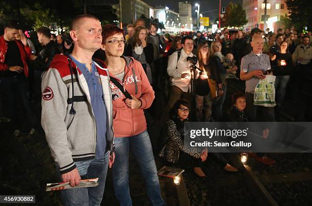 People, walking along the same route marched by 70,000 protesters demanding freedom 25 years before, stop to watch one of many performances...