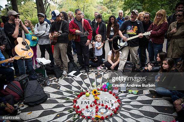 Fans of John Lennon sing songs performed by Lennon and The Beatles around the "Imagine" tile mosaic in the Strawberry Fields section of Central Park...