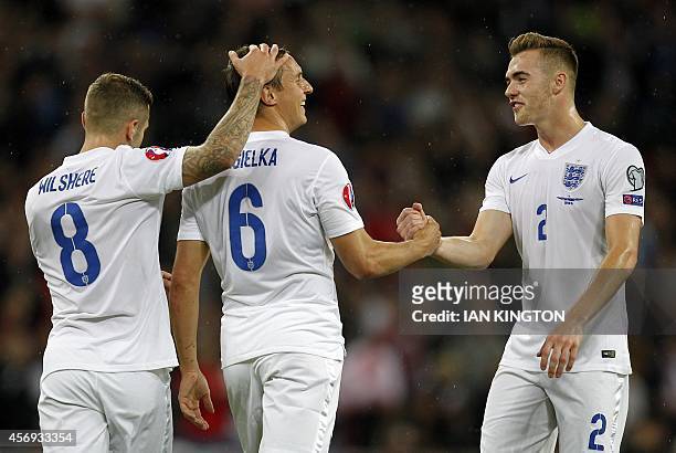 England's defender Phil Jagielka is congratulated by England's midfielder Jack Wilshere and Calum Chambers after he scored his team's first goal...