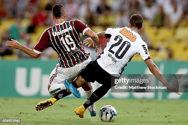 Édson of Fluminense is tackled by Alex of Atletico MG during a match between Fluminense and Atletico MG as part of Brasileirao Series A 2014 at...