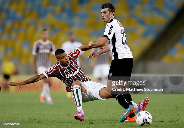 Kenedy of Fluminense is tackled by Dátolo of Atletico MG during a match between Fluminense and Atletico MG as part of Brasileirao Series A 2014 at...