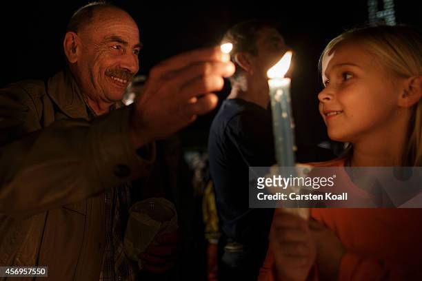 Man lights a candle on Augustplatz square during commemorations October 9, 2014 in Leipzig, Germany. The commemorations mark the 25th anniversary of...
