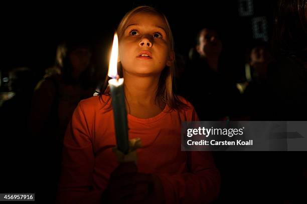 Girl holds a candle on Augustplatz square during commemorations October 9, 2014 in Leipzig, Germany. The commemorations mark the 25th anniversary of...
