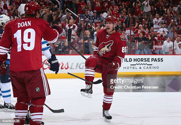 Mikkel Boedker of the Arizona Coyotes celebrates with Shane Doan after Boedker scored a first period goal against the Winnipeg Jets during the NHL...