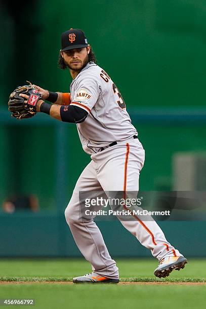 Brandon Crawford of the San Francisco Giants makes a throw to first base in the third inning during Game One of the National League Division Series...