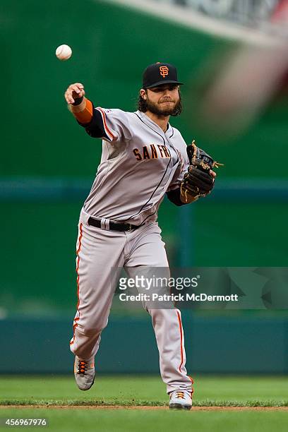 Brandon Crawford of the San Francisco Giants makes a throw to first base in the third inning during Game One of the National League Division Series...