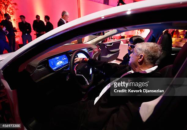 Tesla owners look at the new interior of a Tesla "D" model electric sedan after Elon Musk, CEO of Tesla, unveiled the dual engine chassis, a faster...