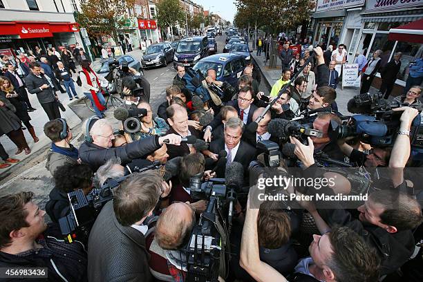 Douglas Carswell of the UK Independence Party and party leader Nigel Farage are surrounded by reporters on October 10, 2014 in Clacton-on-Sea,...