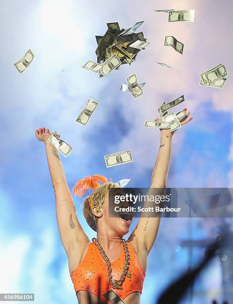 Miley Cyrus throws money in the air as she performs at the opening night of her Bangerz Tour in Australia at Rod Laver Arena on October 10, 2014 in...