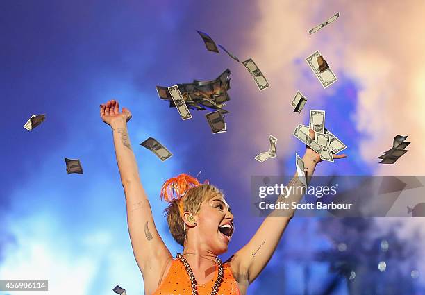 Miley Cyrus throws money in the air as she performs at the opening night of her Bangerz Tour in Australia at Rod Laver Arena on October 10, 2014 in...