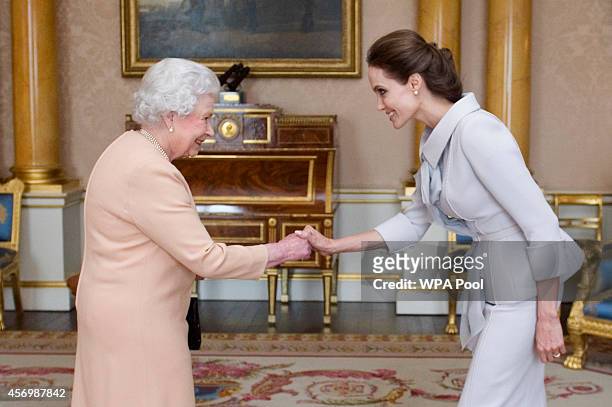 Actress Angelina Jolie is presented with the Insignia of an Honorary Dame Grand Cross of the Most Distinguished Order of St Michael and St George by...