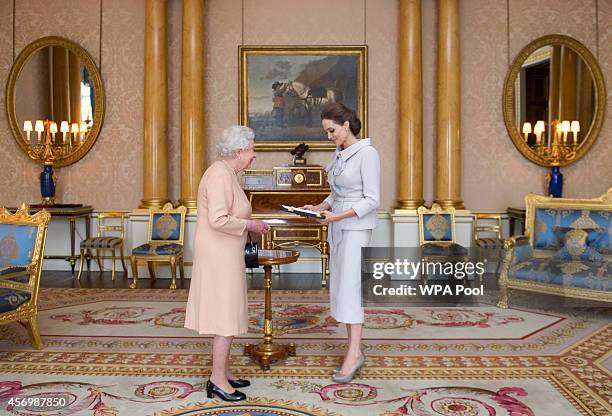 Actress Angelina Jolie is presented with the Insignia of an Honorary Dame Grand Cross of the Most Distinguished Order of St Michael and St George by...