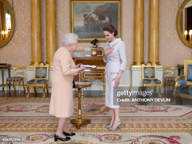 Actress Angelina Jolie is presented with the Insignia of an Honorary Dame Grand Cross of the Most Distinguished Order of St Michael and St George by...