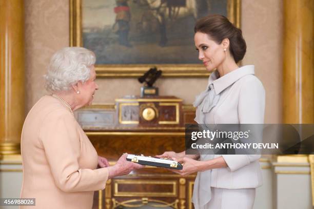 Actress Angelina Jolie is presented with the Insignia of an Honorary Dame Grand Cross of the Most Distinguished Order of St Michael and St George by...