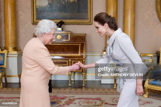 Actress Angelina Jolie is presented with the Insignia of an Honorary Dame Grand Cross of the Most Distinguished Order of St Michael and St George by...