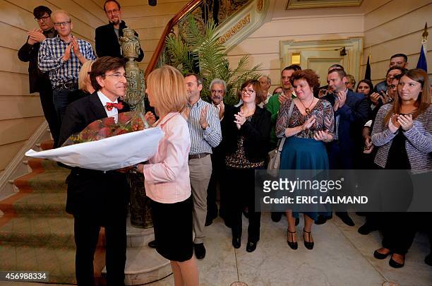 Outgoing Prime Minister Elio Di Rupo receives a bunch of flowers during the farewell ceremony held for the members of his cabinet, on October 10,...