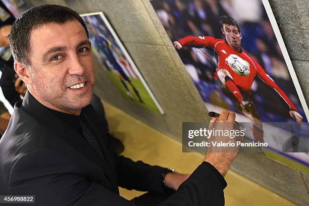 Hakan Sukur signs a picture after the Golden Foot Award press conference at Grimaldi Forum on October 10, 2014 in Monte-Carlo, Monaco.