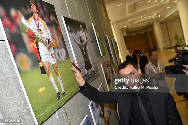 Hakan Sukur signs a picture after the Golden Foot Award press conference at Grimaldi Forum on October 10, 2014 in Monte-Carlo, Monaco.