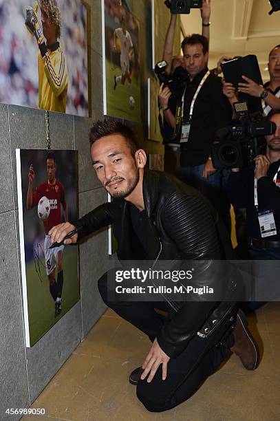 Hidetoshi Nakata signs a picture after the Golden Foot Award press conference at Grimaldi Forum on October 10, 2014 in Monte-Carlo, Monaco.