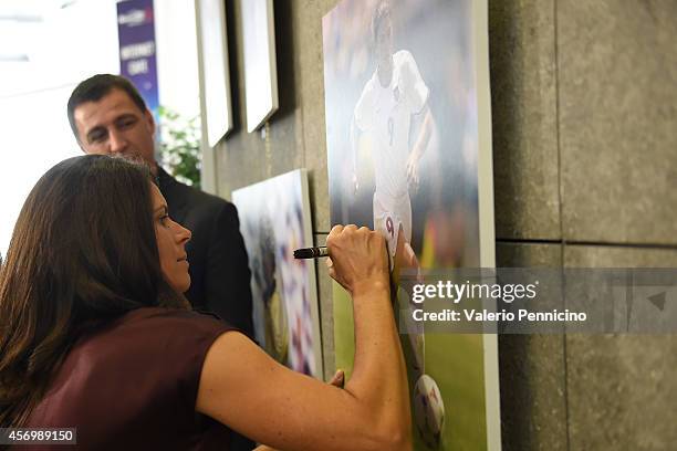 Mia Hamm signs a picture after the Golden Foot Award press conference at Grimaldi Forum on October 10, 2014 in Monte-Carlo, Monaco.
