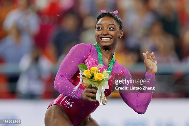 Gold medalist Simone Biles of United States avoids a bee during the medal ceremony after the Women's All-Around Final in day four of the 45th...