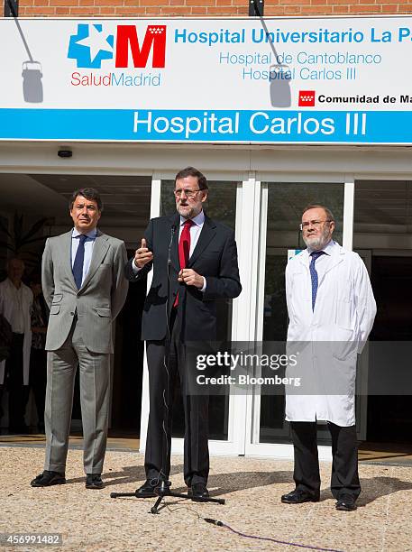 Mariano Rajoy, Spain's prime minister, center, stands with Ignacio Gonzalez, Madrid's regional government president, left, and Rafael Perez de...