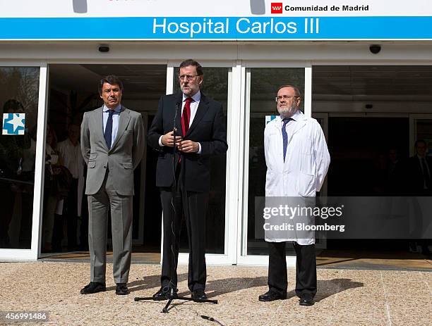 Mariano Rajoy, Spain's prime minister, center, stands with Ignacio Gonzalez, Madrid's regional government president, left, and Rafael Perez de...