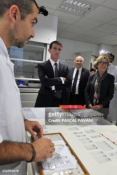 French Prime Minister Manuel Valls , flanked by French junior minister for Higher Education and Research Genevieve Fioraso , visits researchers at...