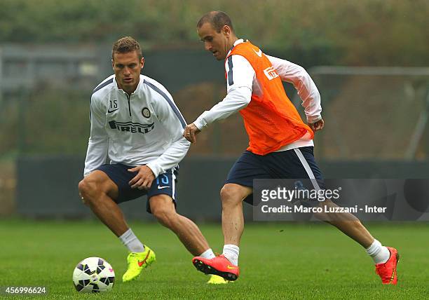 Rodrigo Palacio competes with Nemanja Vidic during FC Internazionale training session at the club's training ground on October 10, 2014 in Appiano...