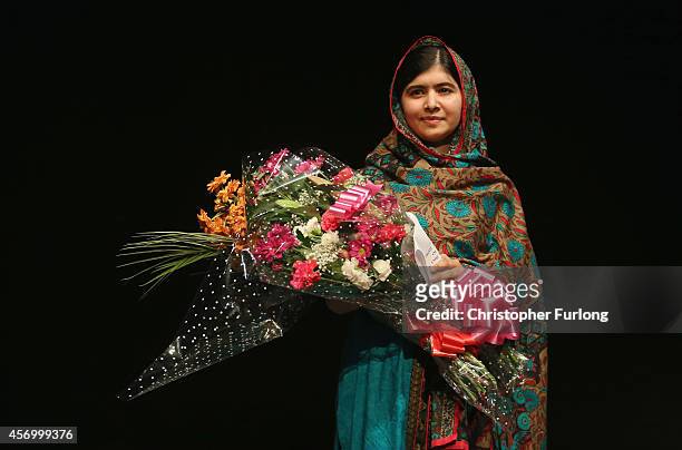 Malala Yousafzai holds a bouquet of flowers, given to her on behalf of the Pakistani Prime Minster during a press conference at the Library of...