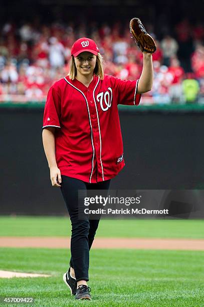 Swimmer Katie Ledecky waves to the crowd after throwing the ceremonial first pitch for Game One of the National League Division Series between the...