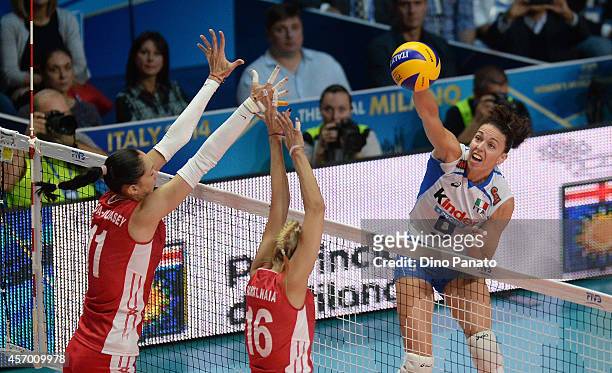Nadia Centoni of Italy spikes the ball against Ekaterina Gamova and Yuliya Podskalnaya of Russia during the FIVB Women's World Championship pool H...
