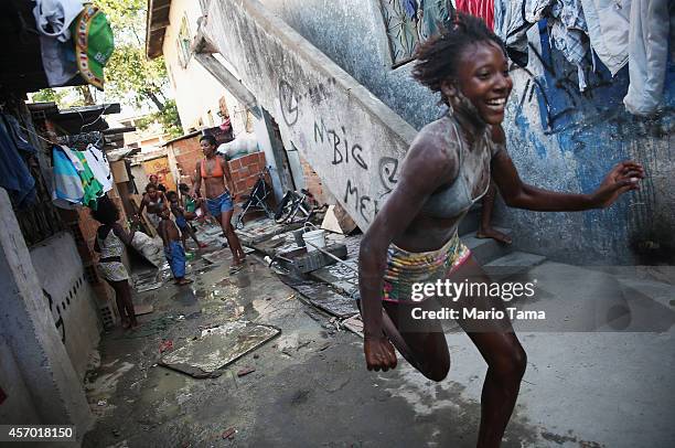 People gather and play in a delapidated section of the occupied Complexo da Mare, one of the largest favela complexes in Rio, on October 10, 2014 in...