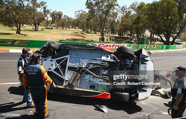 The Holden Racing Team Holden of Warren Luff is seen on its side after a crash with Craig Lowndes driver of the Red Bull Racing Australia Holden...