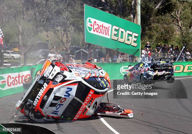 The Holden Racing Team Holden of Warren Luff is seen on its side after a crash with Craig Lowndes driver of the Red Bull Racing Australia Holden...