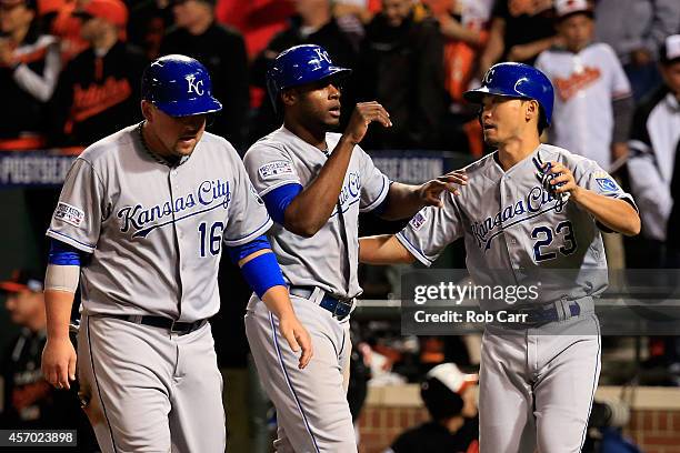 Lorenzo Cain, Billy Butler and Norichika Aoki celebrate after scoring on Alex Gordon of the Kansas City Royals double to right field because of an...