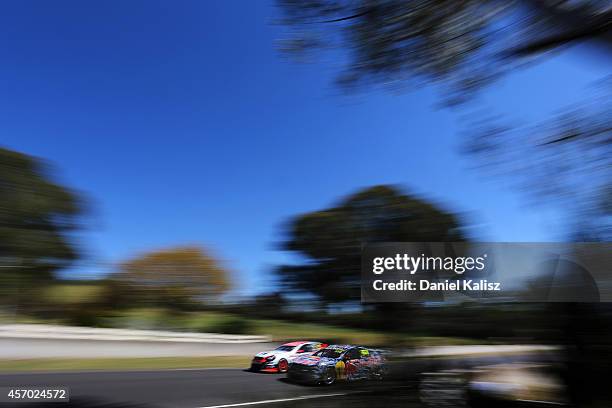 Warren Luff drives the Holden Racing Team Holden passes Craig Lowndes drives the Red Bull Racing Australia Holden during practice for the Bathurst...