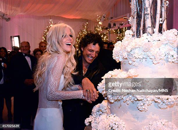 Michaele Schon and Neal Schon cut the cake by Sam Godfrey at their wedding at the Palace of Fine Arts on December 15, 2013 in San Francisco,...