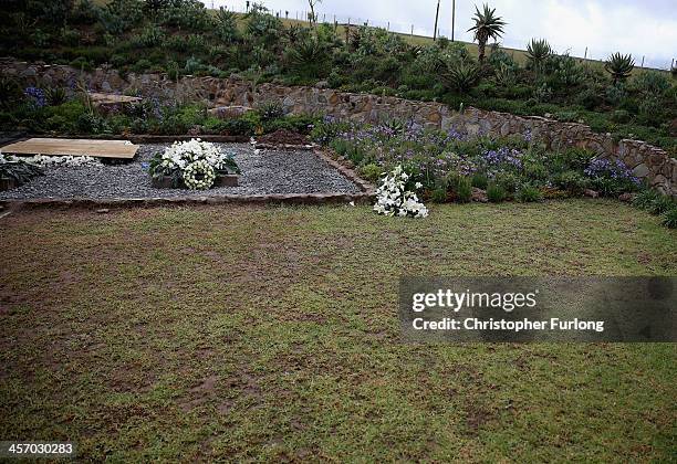 The grave of former South African President Nelson Mandela is covered with flowers in is home village of Qunu on December 16, 2013 in Qunu, South...