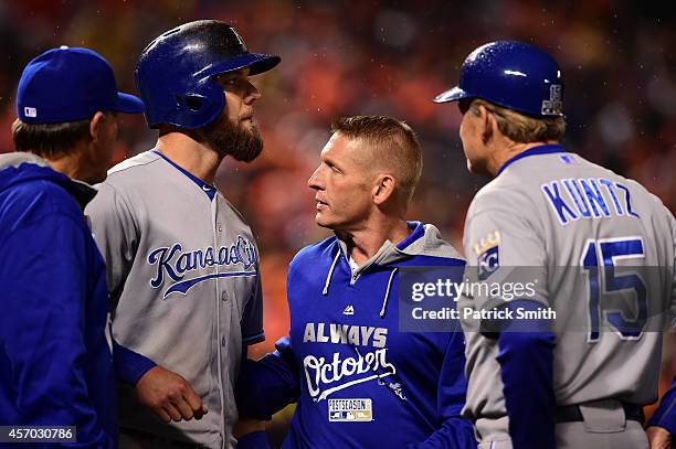 Alex Gordon of the Kansas City Royals gets looked over by the trainer after getting hit in the head by a pitch from Andrew Miller of the Baltimore...