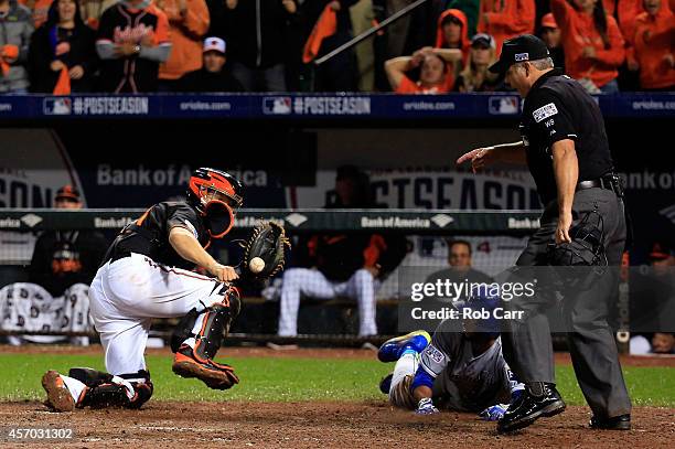 Alcides Escobar gets tagged out by Nick Hundley of the Baltimore Orioles on a grounded ball hit by Eric Hosmer of the Kansas City Royals to first...