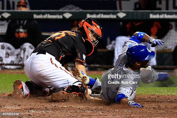 Alcides Escobar gets tagged out by Nick Hundley of the Baltimore Orioles on a grounded ball hit by Eric Hosmer of the Kansas City Royals to first...