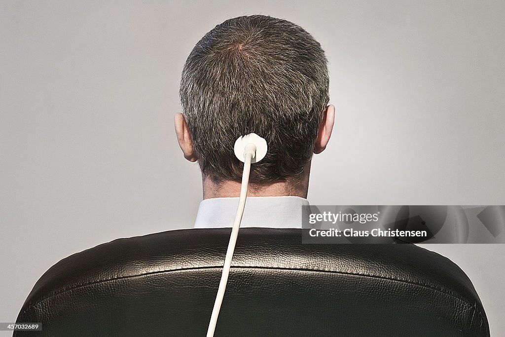 Man on chair with cable on head