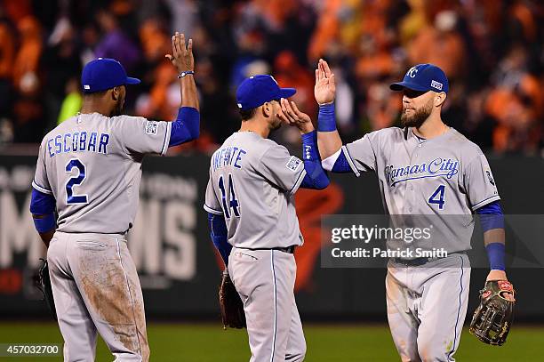 Alex Gordon of the Kansas City Royals celebrates with his teammates Omar Infante and Alcides Escobar after defeating the Baltimore Orioles 8 to 6 in...