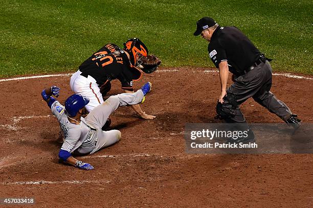 Alcides Escobar gets tagged out by Nick Hundley of the Baltimore Orioles on a grounded ball hit by Eric Hosmer of the Kansas City Royals to first...