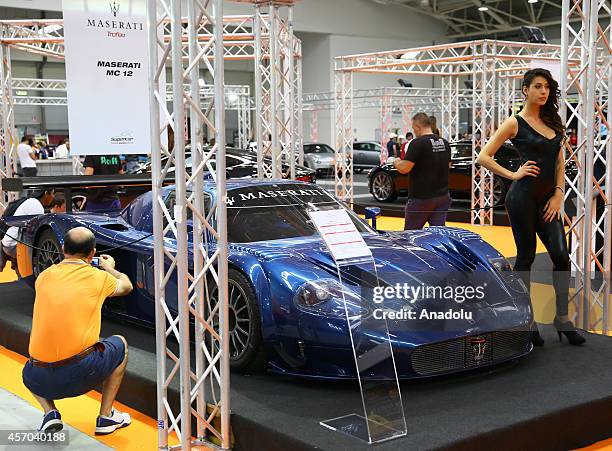 Model poses next to a Maserati MC-12 presented during the Supercar Roma Auto Show in Rome, capital city of Italy, on October 10, 2014.