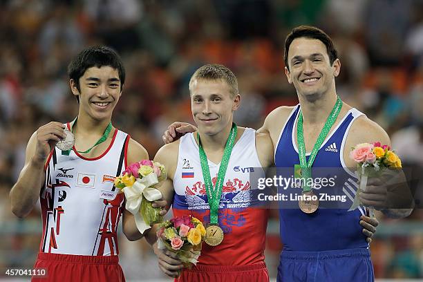 Silver medalist Kenzo Shirai of Japan, gold medalist Denis Abliazin of Russia and bronze medalist Diego Hypolito of Brazil celebrate during the medal...