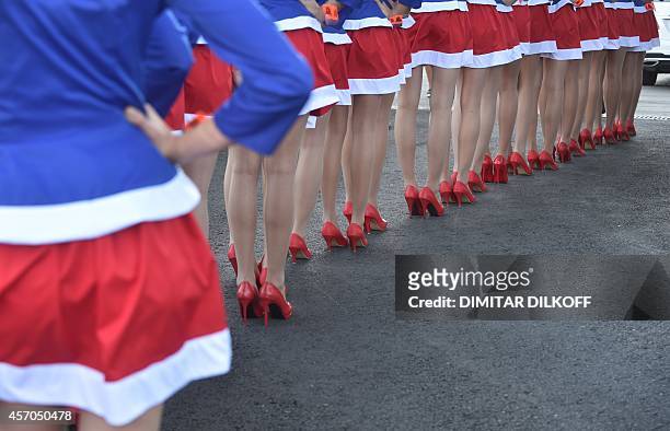 Pit lane girls line up during the qualifying session of the inaugural Russian Grand Prix at the Sochi Autodrom in Sochi on October 11, 2014. AFP...